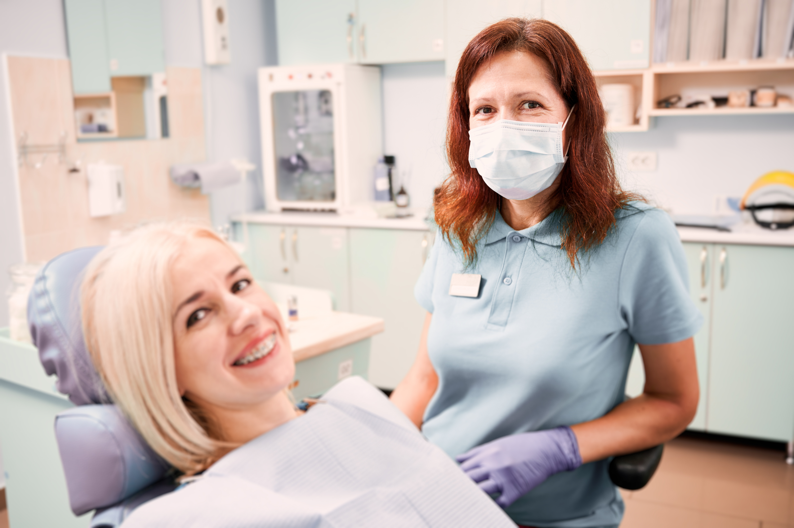 female doctor sitting beside patient in dental office scaled