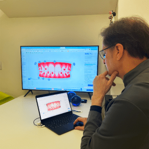 Dr. Pedro Barini analisando detalhadamente um modelo digital 3D de uma arcada dentária, planejando um tratamento ortodôntico com precisão e cuidado.