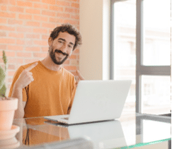 Ortodontia antes e depois: Homem sorrindo e trabalhando em um laptop, usando aparelho ortodôntico, representando a integração do tratamento na vida diária e o processo durante o tratamento.